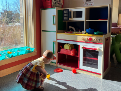 Toddler playing with a colorful play kitchen