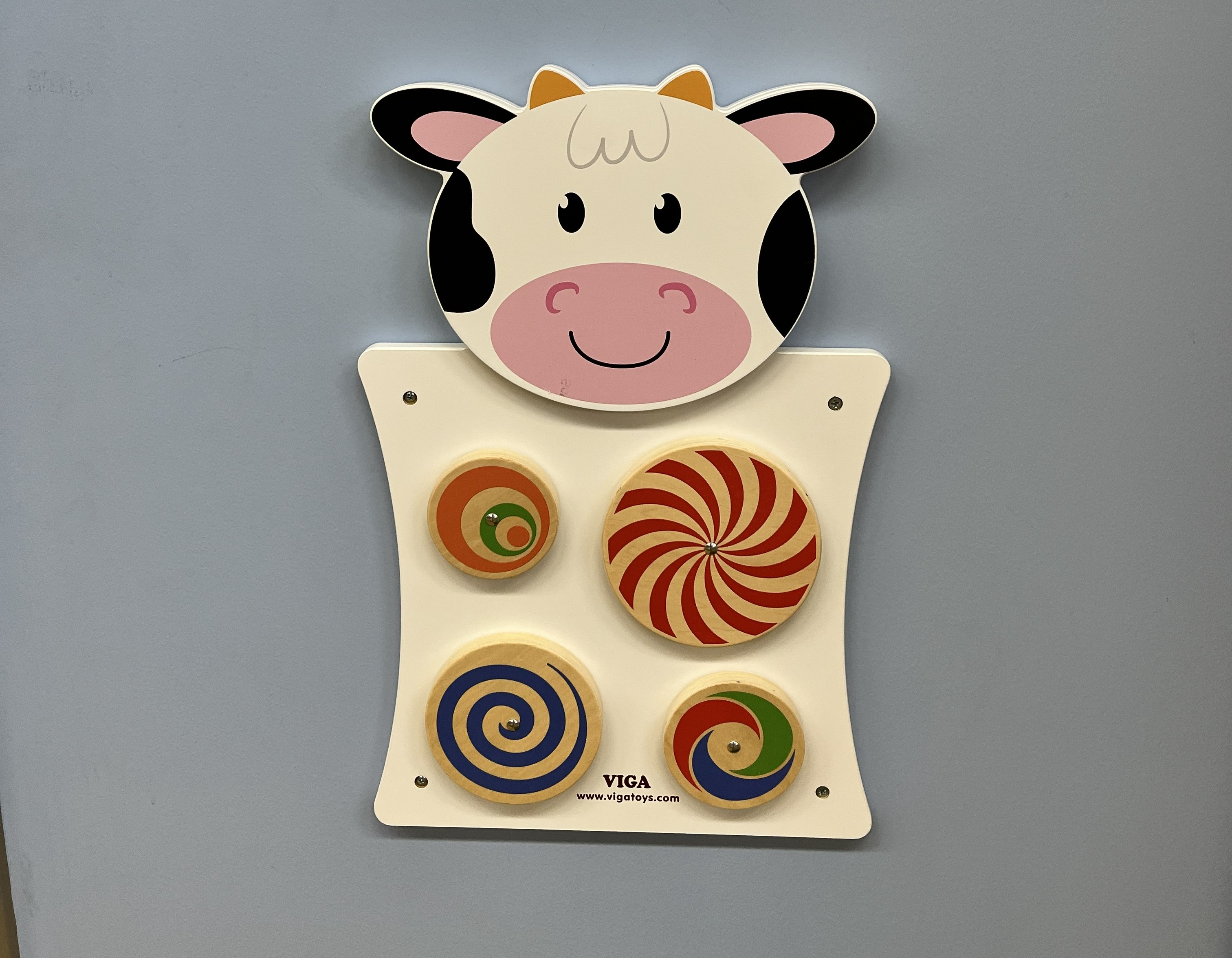 4 spinning wheels on a cow shaped wall panel