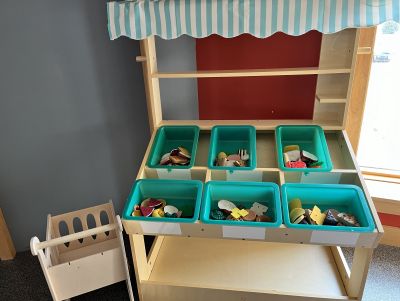 wooden display with play food and shopping cart